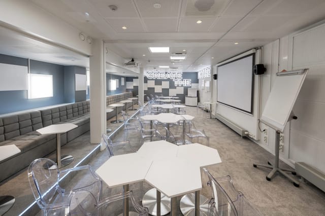 Modern meeting space with hexagonal tables for workshops and brainstorming sessions.