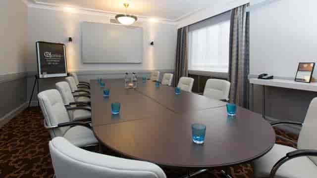Rochester Room in The Queens, Leeds: elegant meeting space with oval table and whiteboard.