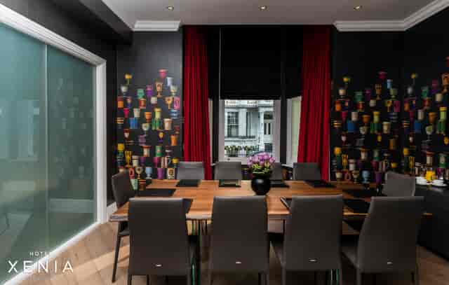 Modern meeting room at Hotel Xenia with wooden table, ideal for collaboration events.
