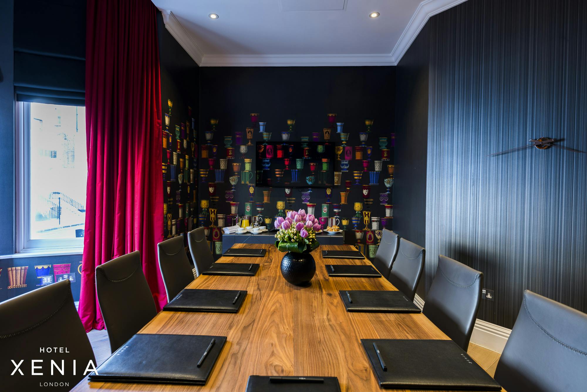 Stylish meeting room at Hotel Xenia with wooden table, ideal for corporate events.