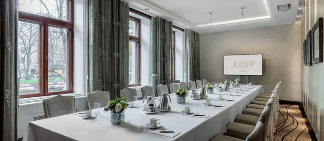Elegant meeting room at Hotel Kamp with natural light, perfect for corporate events.