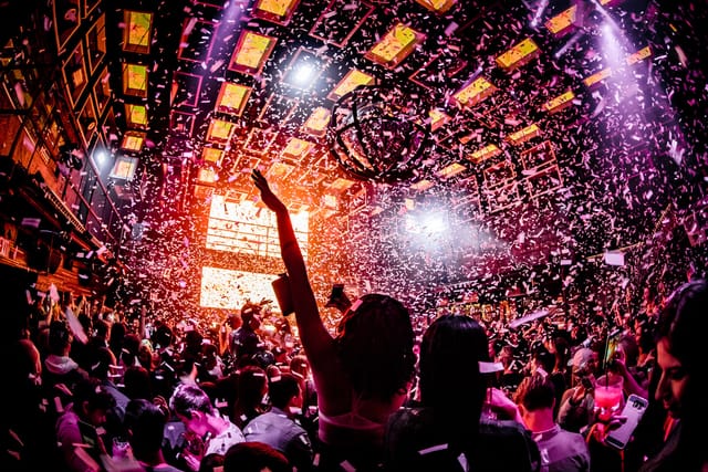 Vibrant Marquee New York event with confetti, lively crowd celebrating a party.