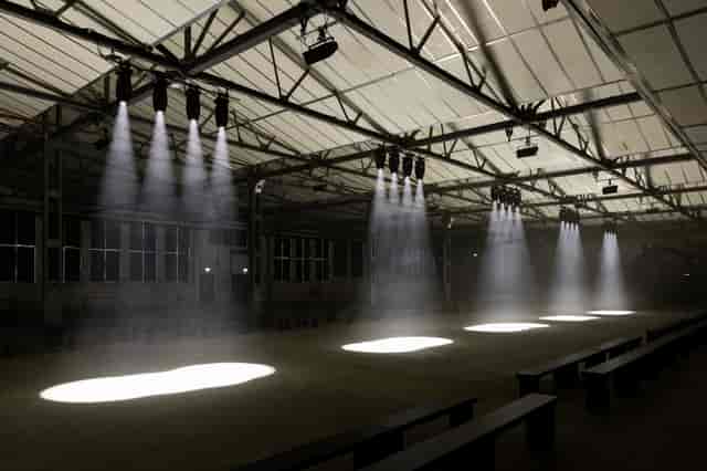 Spacious event venue with dramatic lighting, perfect for fashion shows and corporate events.