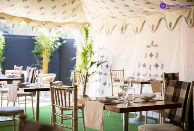 Elegant outdoor event space under a tent with fine dining setup for upscale gatherings.