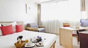 Business hotel room in Novotel Paris with cozy seating and workspace for meetings.
