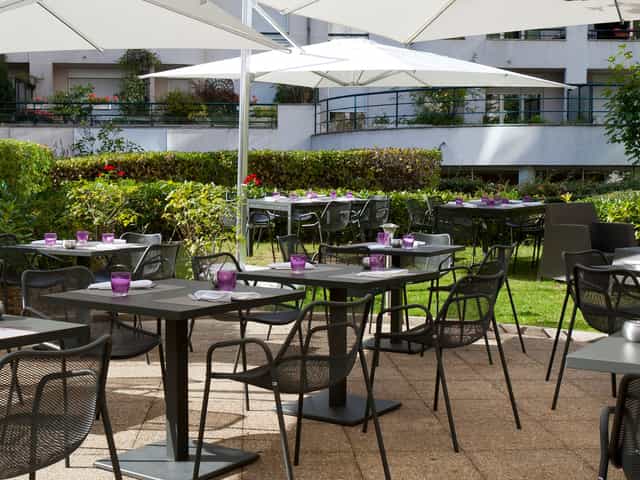 Outdoor event space at Novotel Paris with vibrant purple accents and greenery.