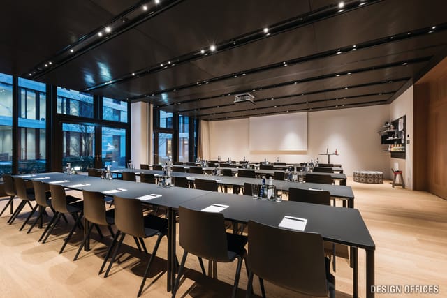 Modern meeting room in Munich with long tables, ideal for corporate events and workshops.