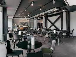Modern event space in Munich with sleek black furniture, ideal for meetings and workshops.