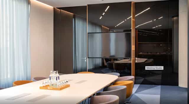 Modern meeting studio in Andaz Munich with oval table, ideal for collaboration and presentations.