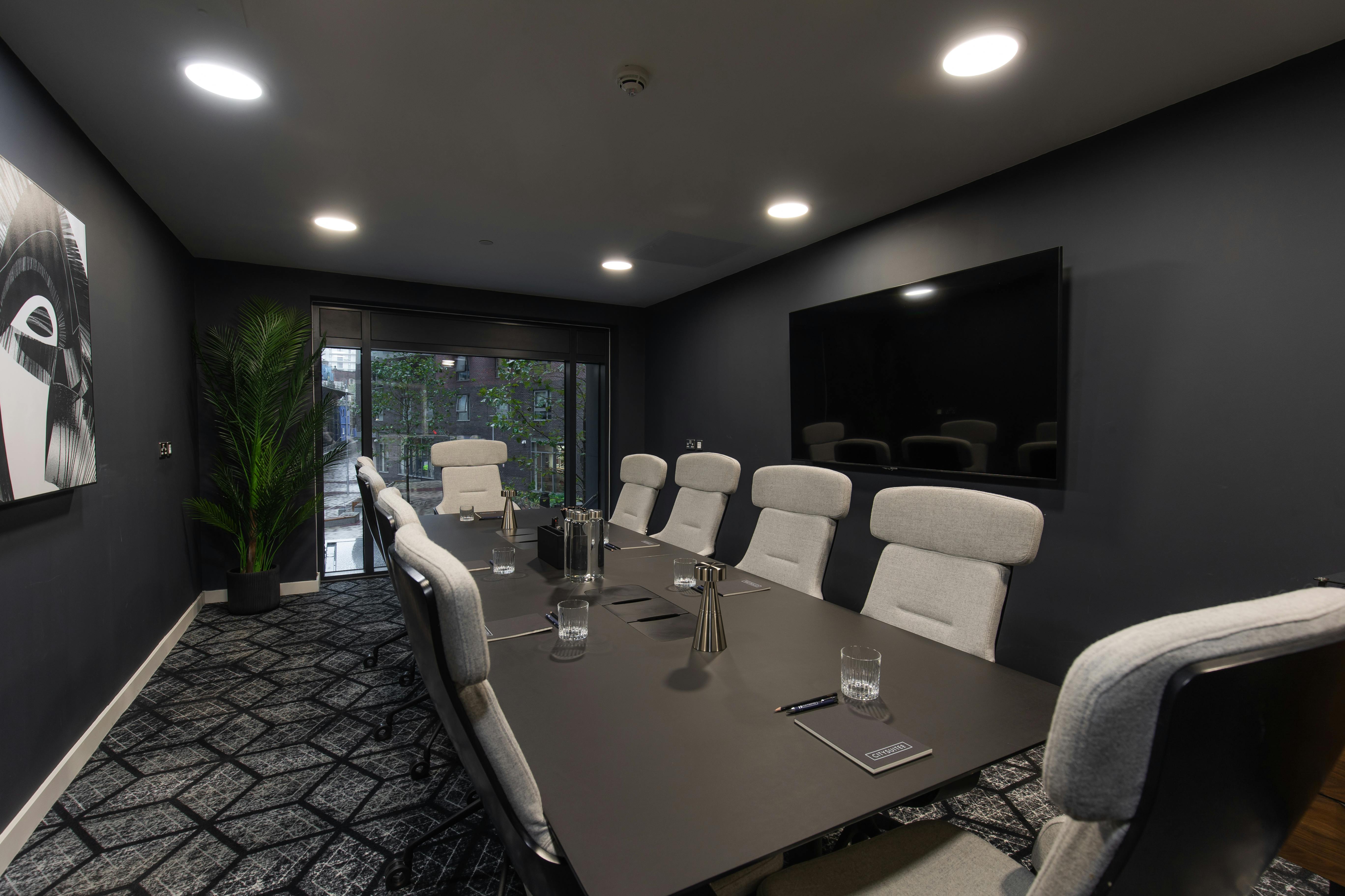 Modern conference room with sleek black walls for professional meetings and events.