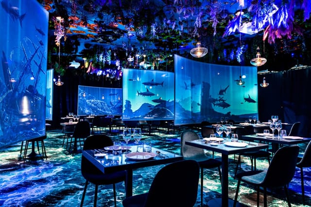 Upscale restaurant event space with vibrant underwater decor for fine dining gatherings.