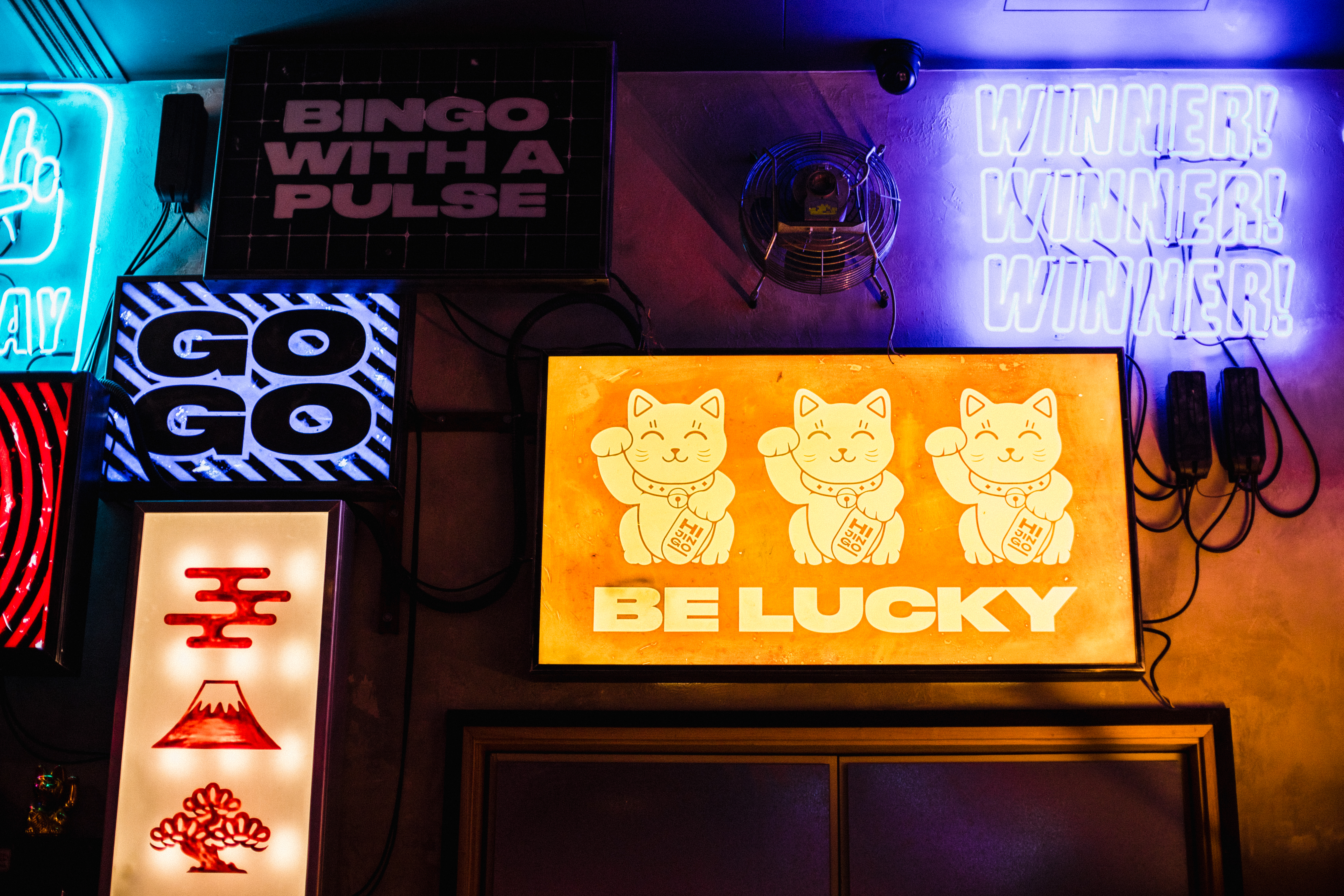 Vibrant Lucky Cat Bar with neon signs, perfect for themed parties and social gatherings. - Banner