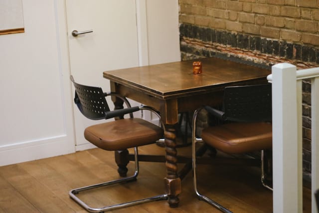 Cozy private dining room with rustic table, perfect for intimate meetings and brainstorming.