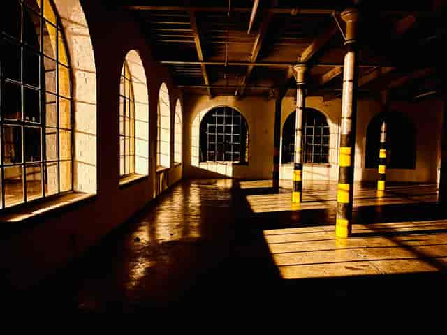 Spacious industrial venue with arched windows, perfect for creative events and workshops.