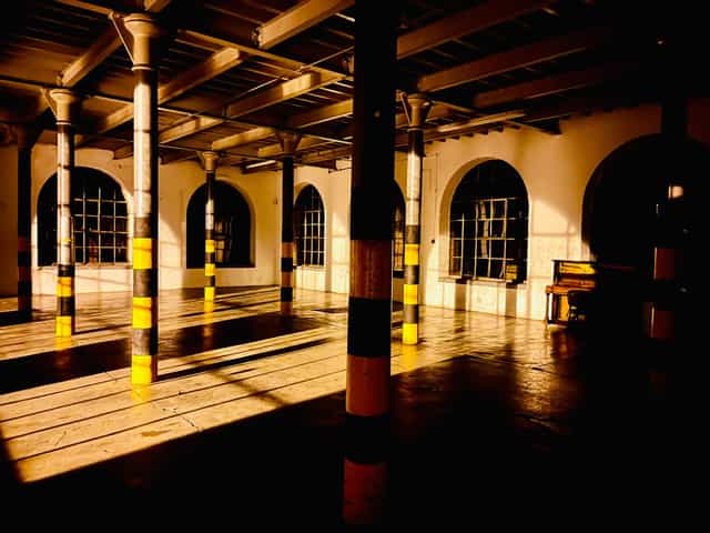 Spacious industrial venue with high ceilings for creative events and workshops.