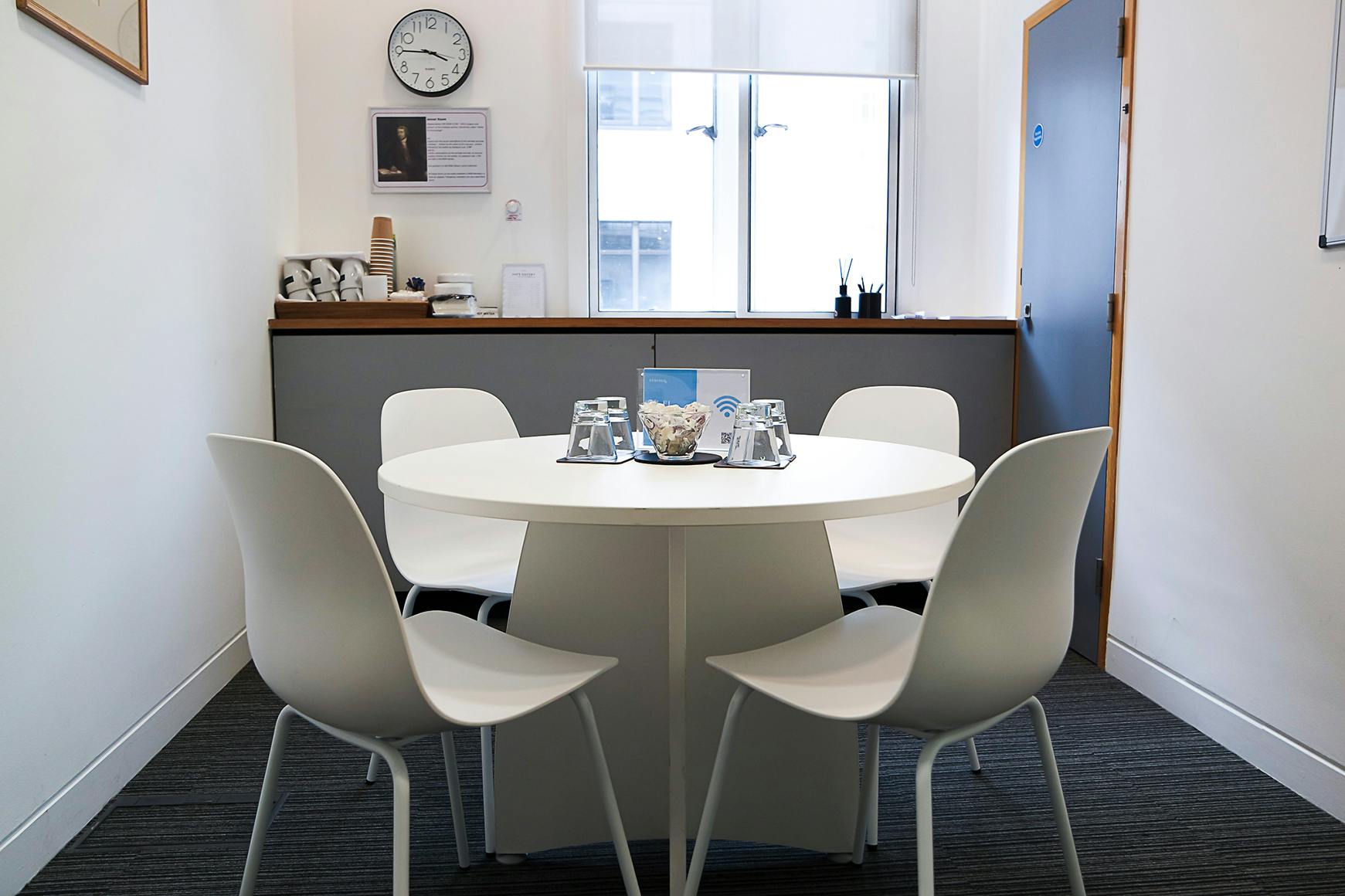 Intimate meeting room with round table at 1 Wimpole Street for client discussions.