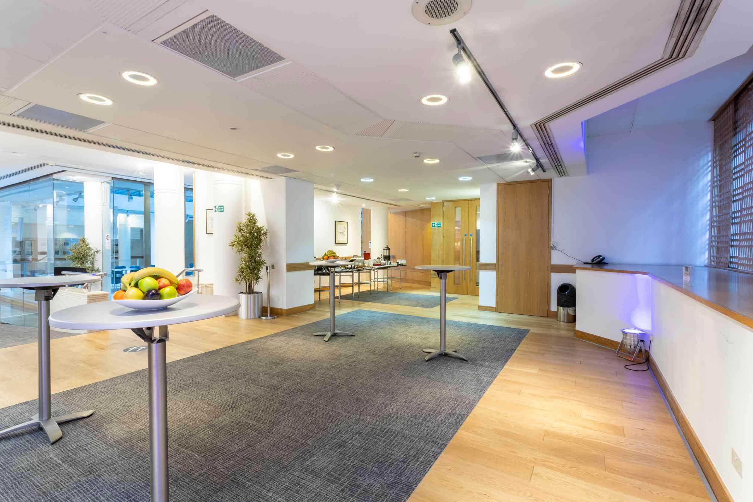 Modern event space with high-top tables for networking at Max Rayne Foyer, 1 Wimpole Street.