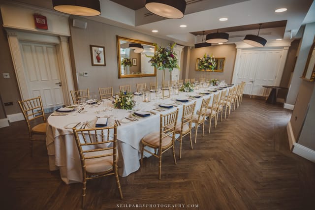 Elegant banquet setup with white linens and gold chairs for corporate events or private dinners.