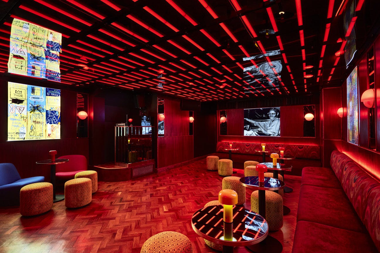 Vibrant basement bar with red and black decor, perfect for networking events and gatherings.