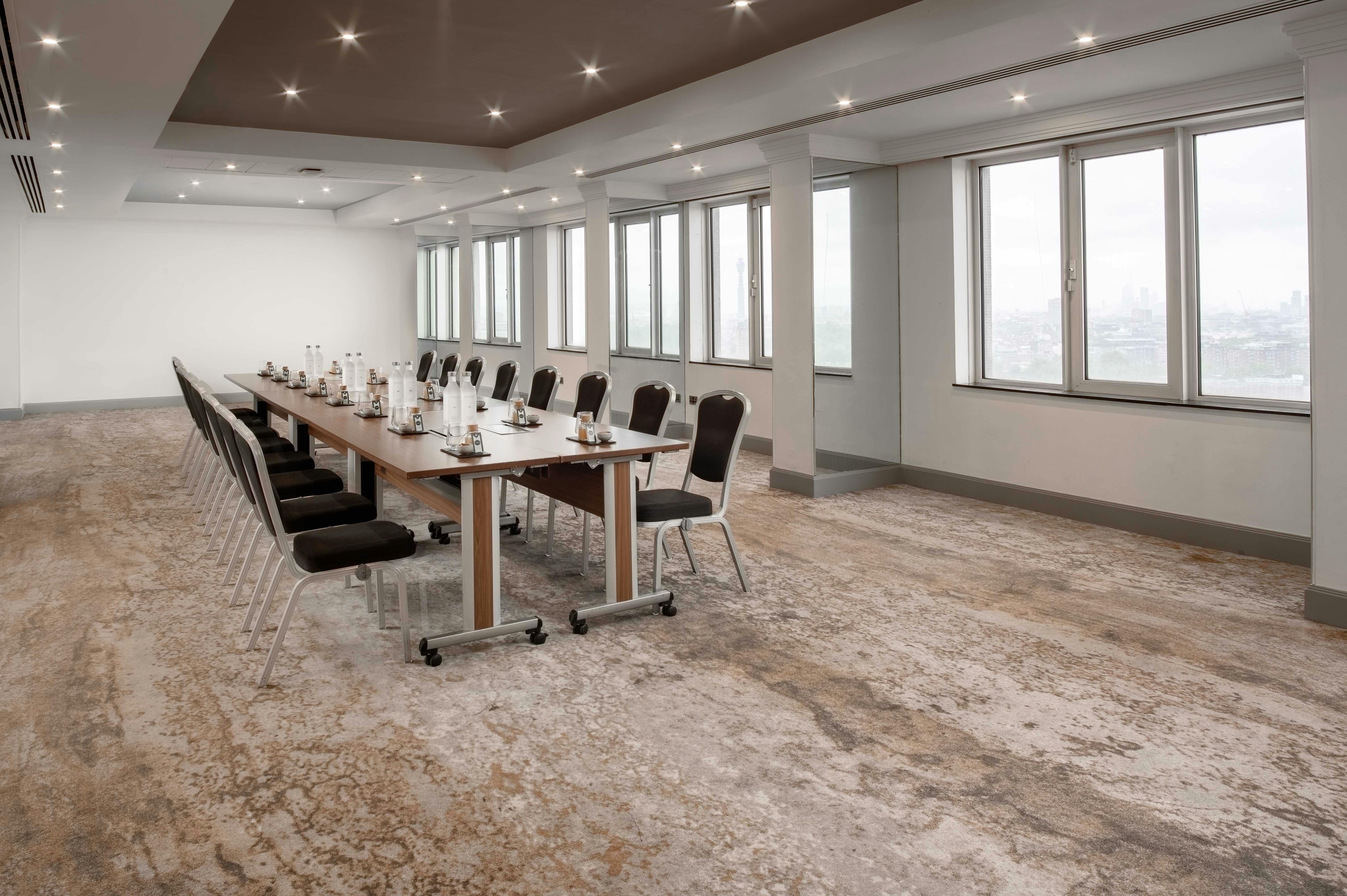 Spacious corporate meeting room with natural light at Hilton London Metropole.