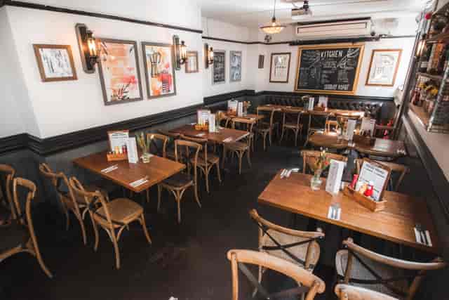 Back Restaurant Area at St Christopher's Inn, ideal for events with wooden tables and natural light.