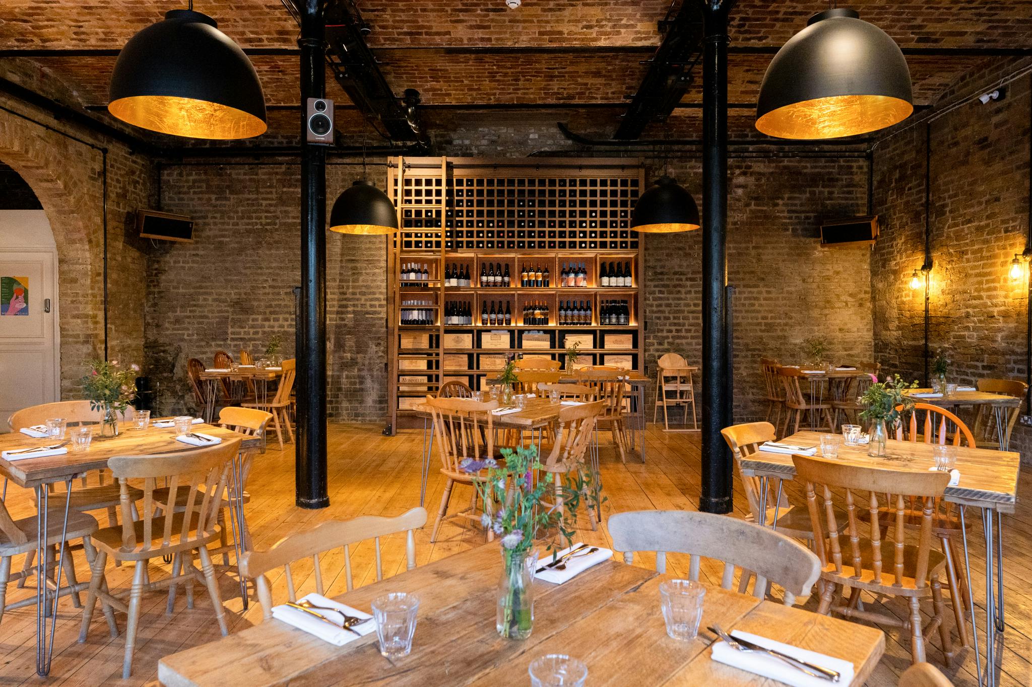 Stylish dining room with wooden tables, ideal for receptions and dinner events.