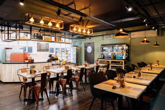 Modern Leslie Forster Suite restaurant with wooden tables, ideal for events and meetings.