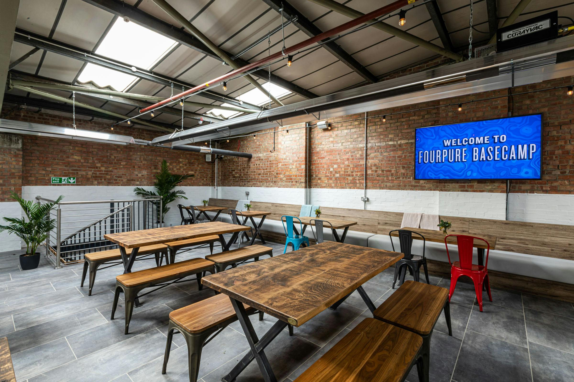 The Mezzanine at Fourpure Taproom, featuring exposed brick, ideal for workshops and meetings.