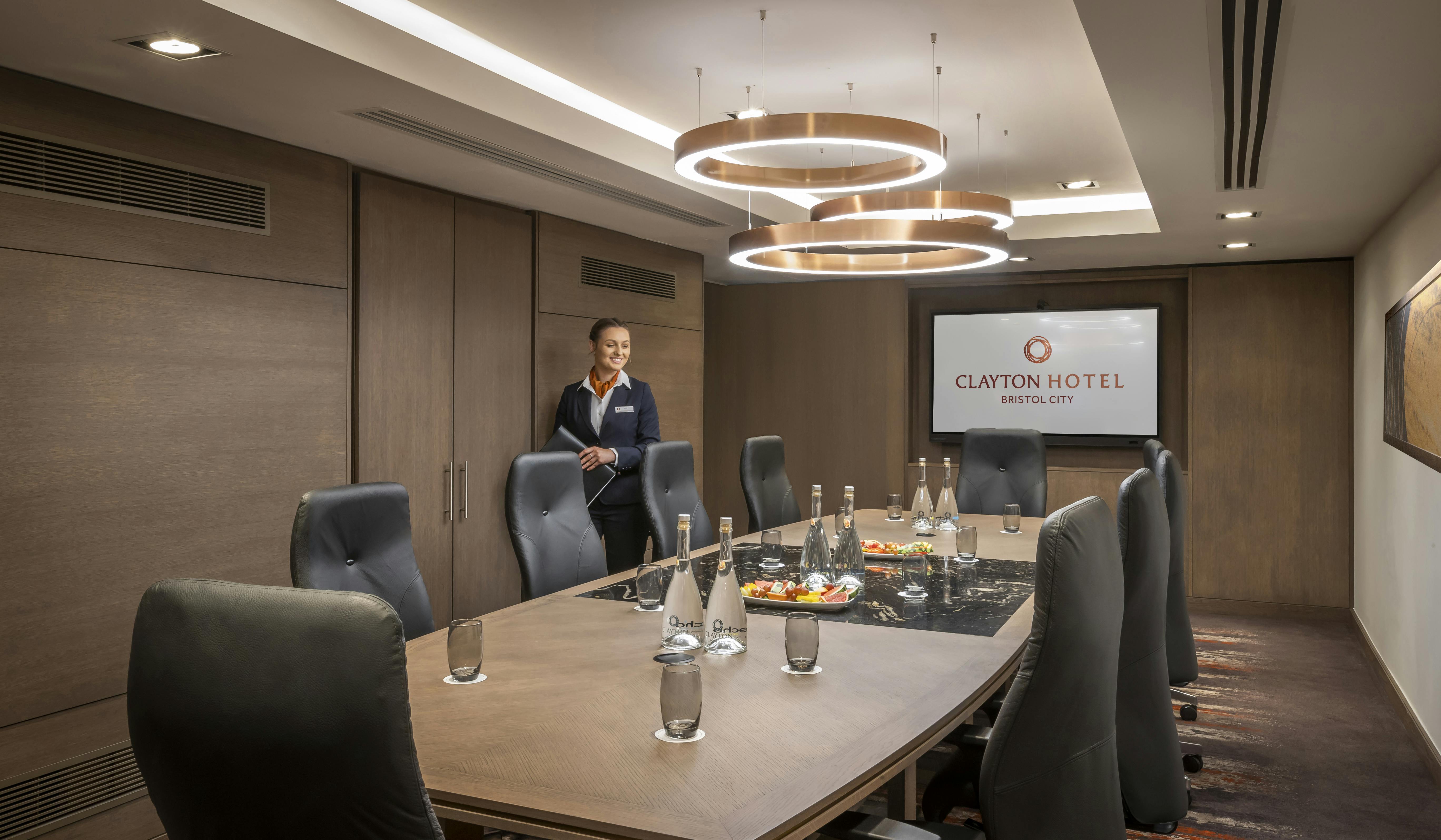 Modern meeting room at Clayton Hotel Bristol with wooden table and leather chairs.