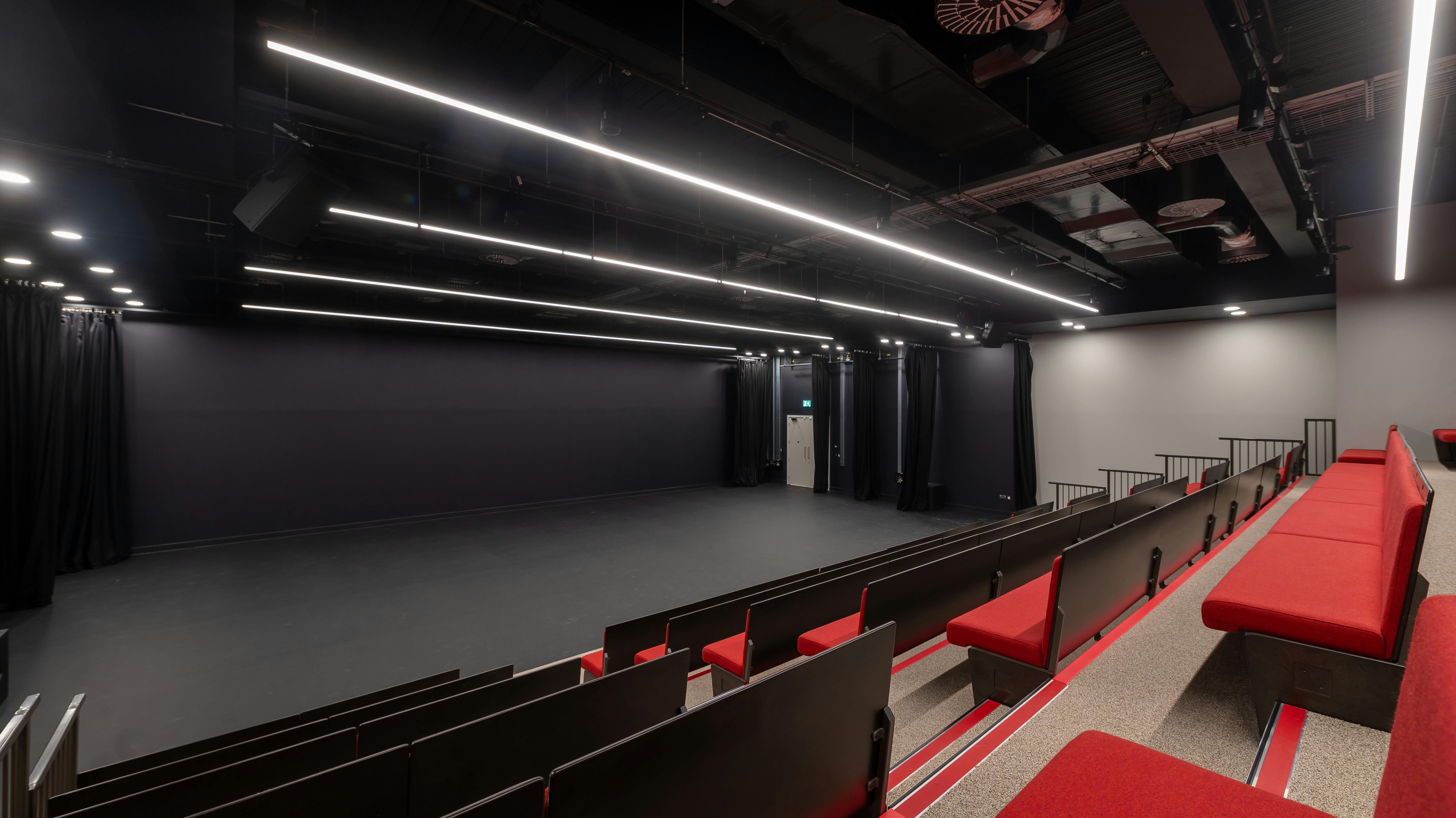 Aud Jebsen Studio Theatre with tiered red seating for performances and corporate events.