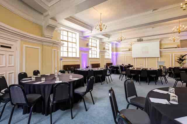 George Thomas in Central Hall Westminster, elegant event space with round tables and projector.