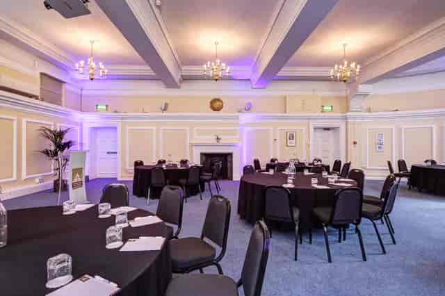 George Thomas in elegant Central Hall Westminster event space with round tables for networking.