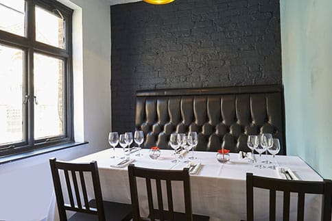 Elegant dining room with plush banquette, perfect for intimate events and meetings.
