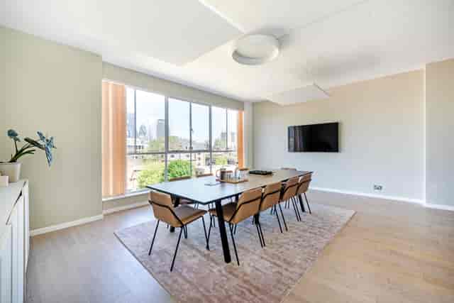 Modern Menier Meeting Room with large table, ideal for collaborative meetings and presentations.