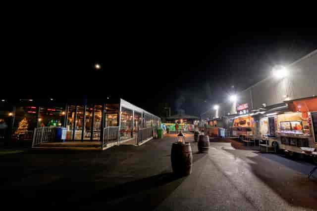 Vibrant outdoor event space at night with food stalls in Twickenham Stoop Stadium.