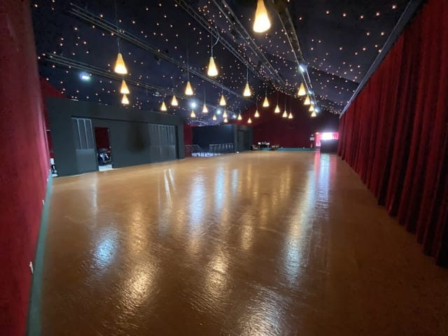 Spacious event venue with polished wooden floor, ideal for corporate and social gatherings.