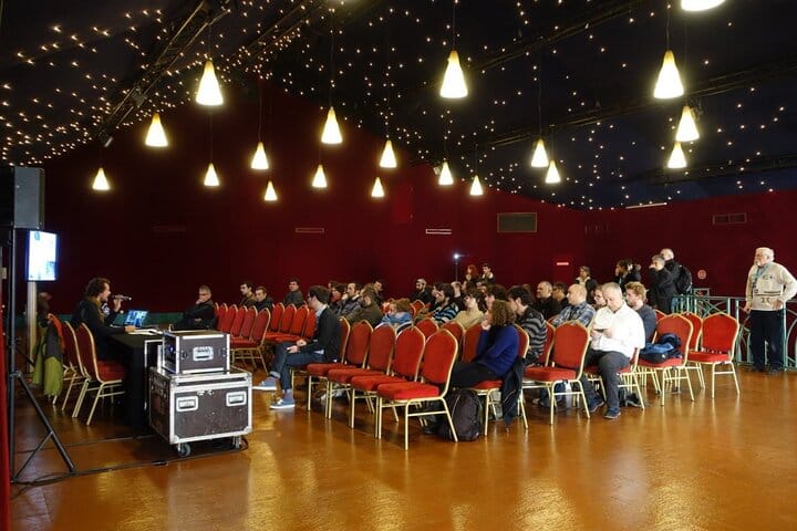 Event space at Dock Haussmann with red chairs, ideal for presentations and meetings.