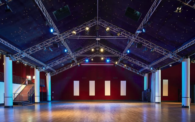 Spacious event venue with high ceiling at Dock Haussmann, ideal for gatherings and presentations.