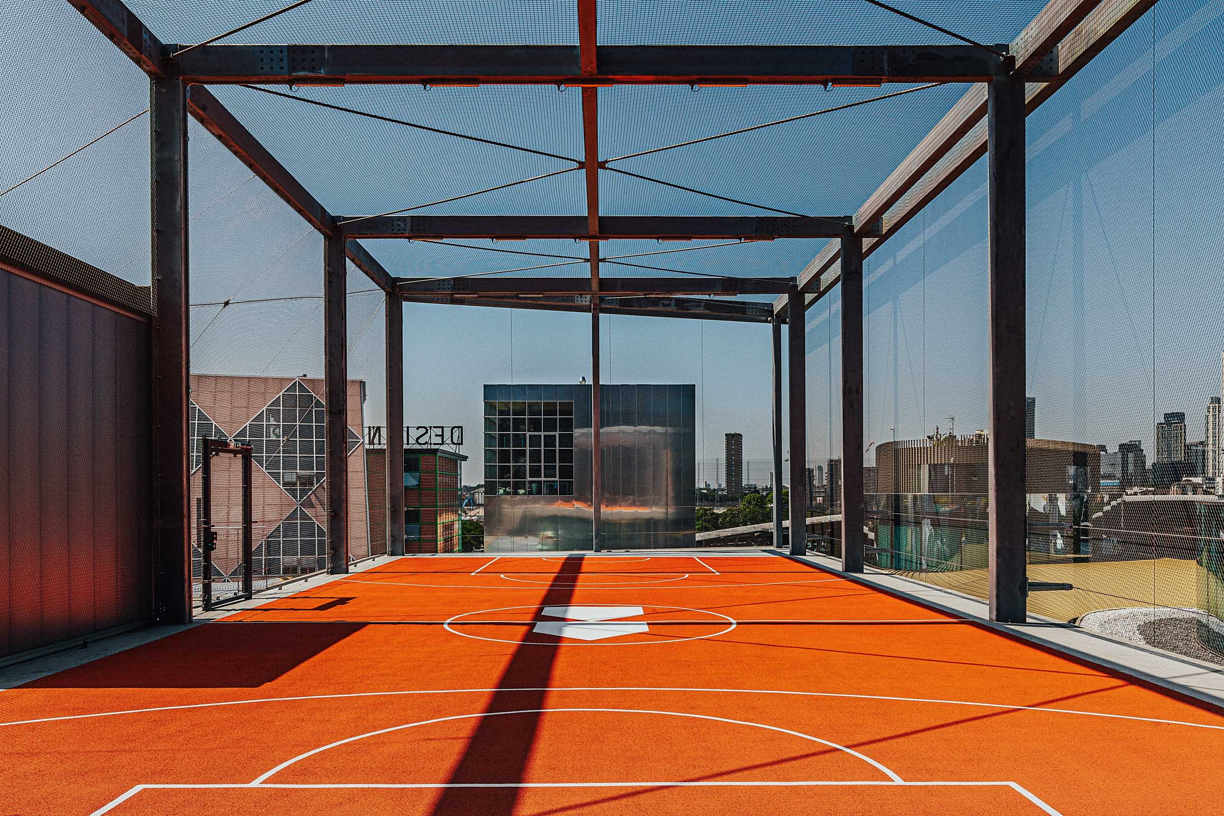 Rooftop event space in Design District London with vibrant orange basketball court. - Banner