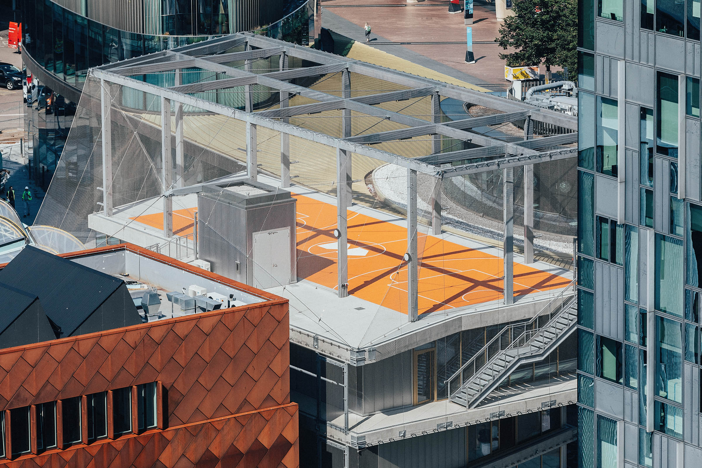 Transparent event space in Design District London with vibrant orange flooring for gatherings. - Banner