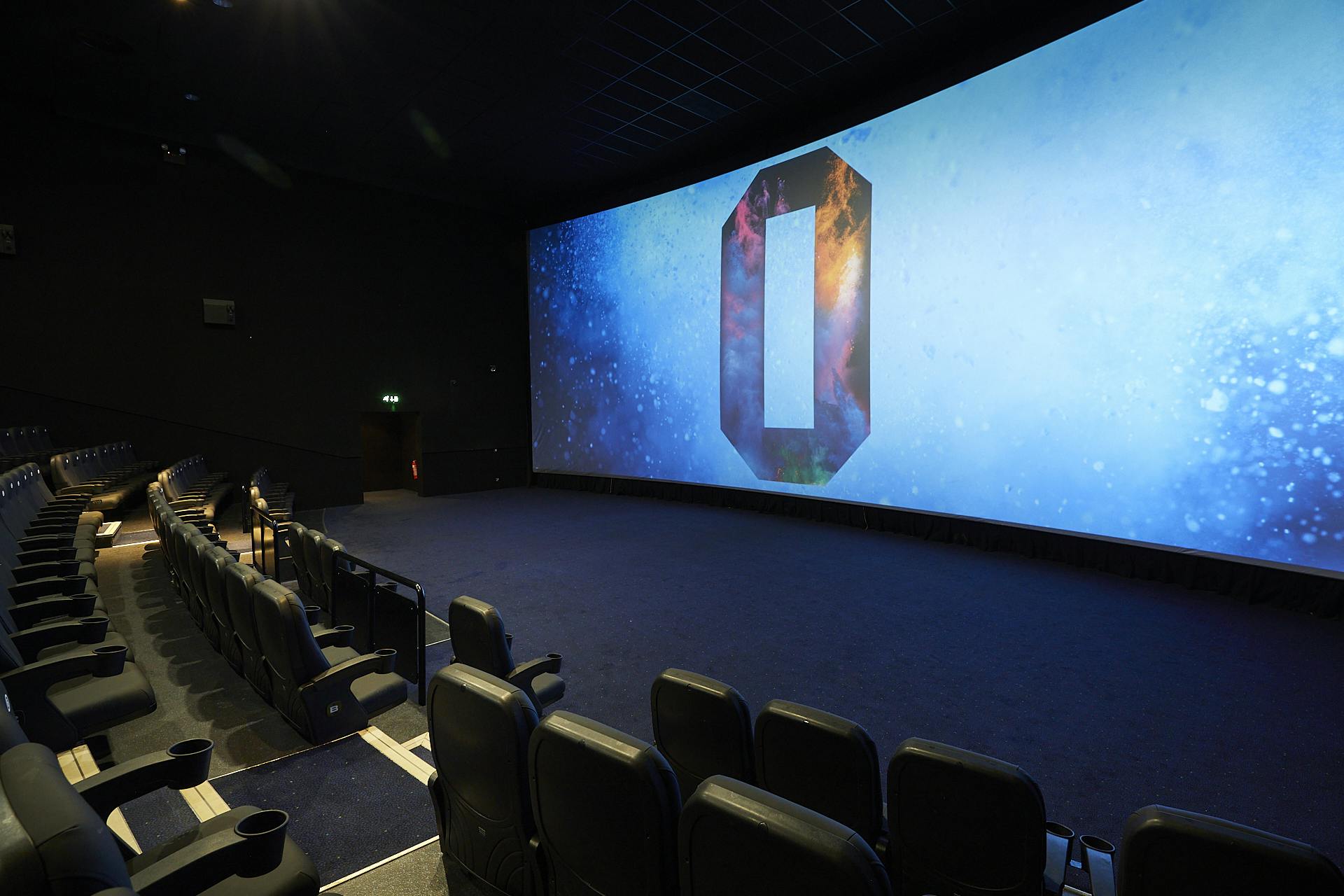 Modern ODEON Greenwich auditorium with curved screen for corporate events and film screenings.