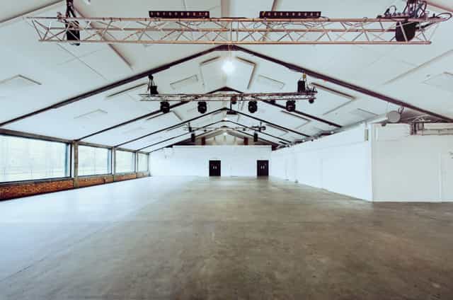 Spacious event venue with high ceilings for conferences and exhibitions at OVAL STUDIOS.