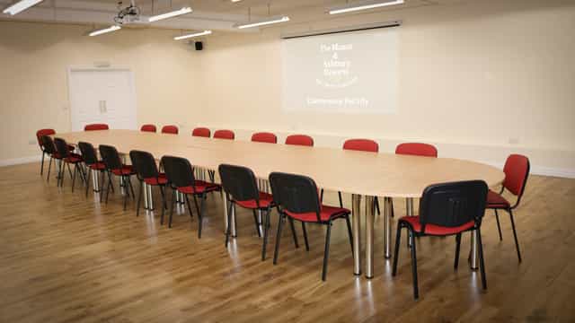 Spacious conference room with oval table, ideal for meetings and presentations.