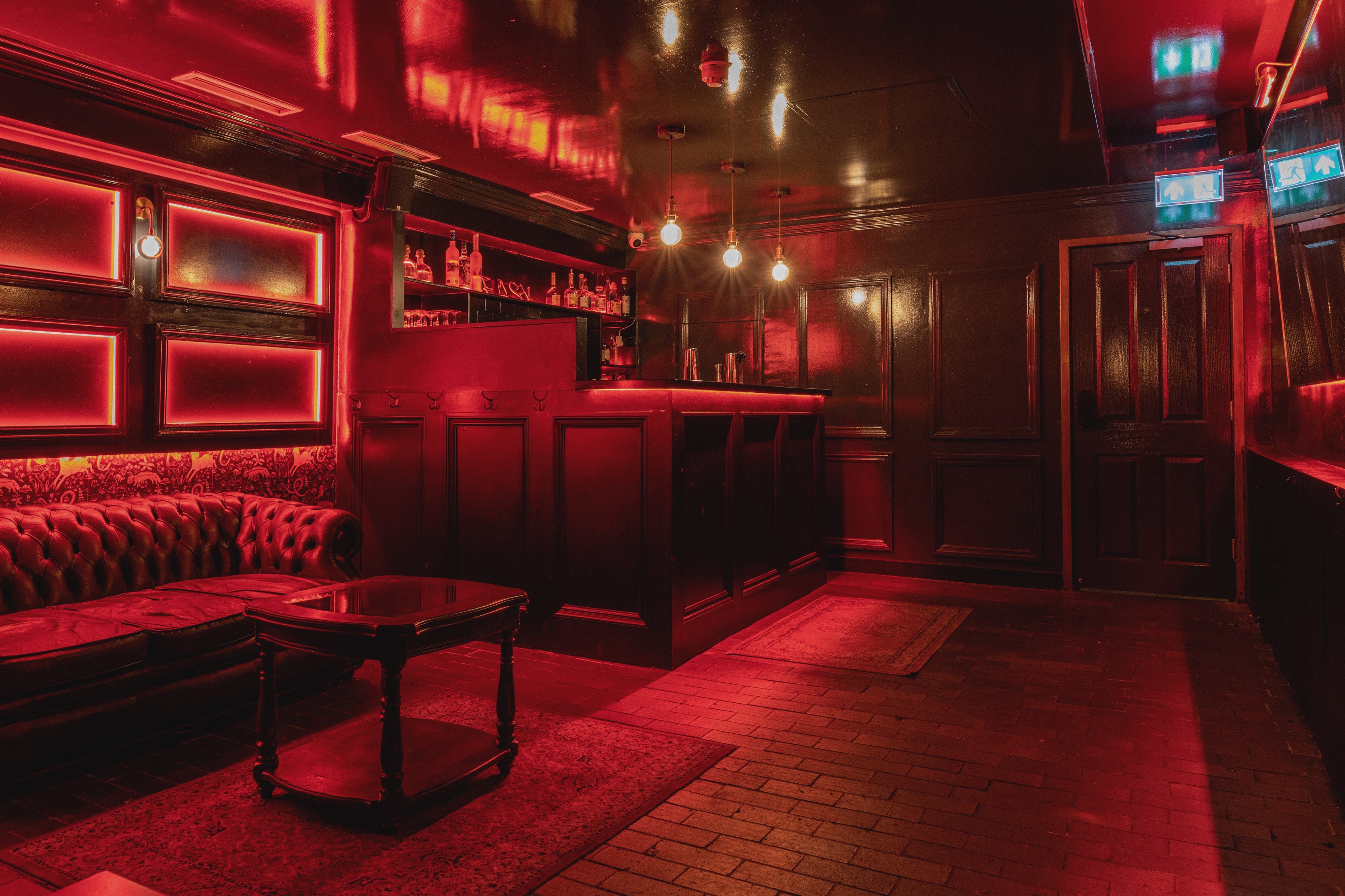 Stylish venue with red ambiance, perfect for cocktail receptions and private events. - Banner