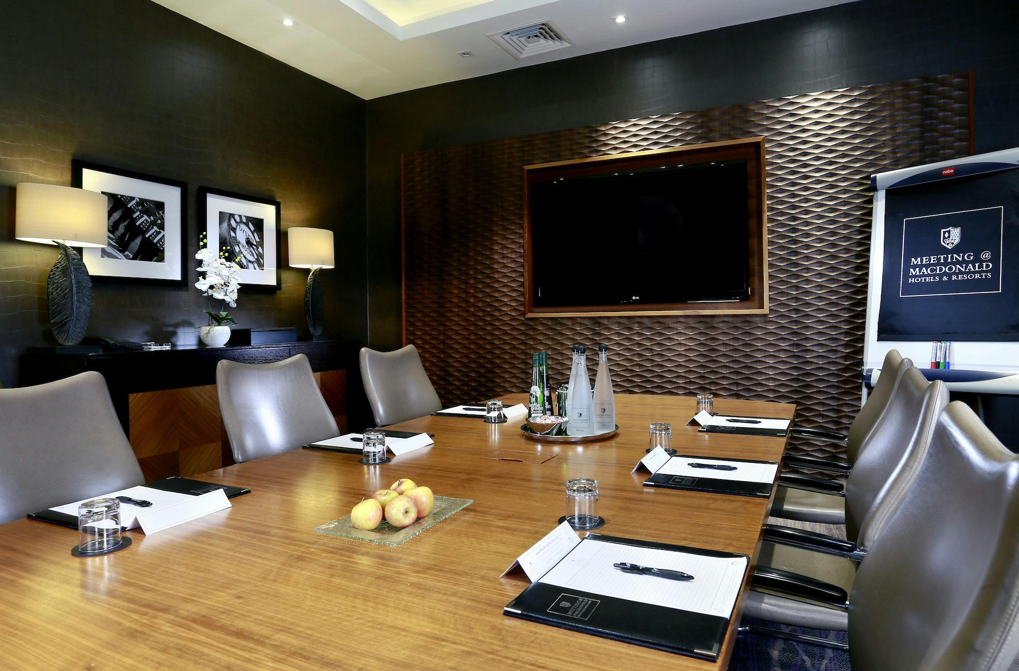 Caley's Brasserie meeting room with sleek table, ideal for professional events.