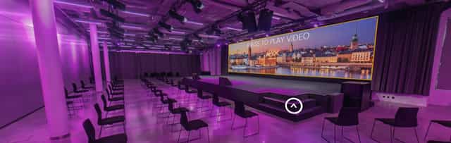 Modern event space with large screen and purple lighting at Hotel At Six.