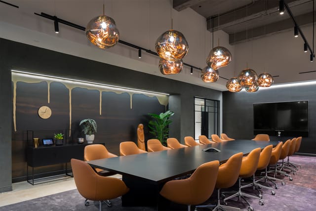Modern conference room at Convene 75 Rockefeller Plaza with sleek table and warm chairs.
