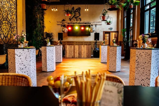 Vibrant event room with cocktail tables and floral arrangements for gatherings.