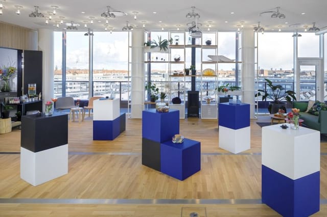 Modern event space in Zoku with geometric pedestals, ideal for showcases and networking.