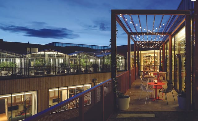 Outdoor event space at Zoku with string lights, ideal for cocktail receptions and networking.